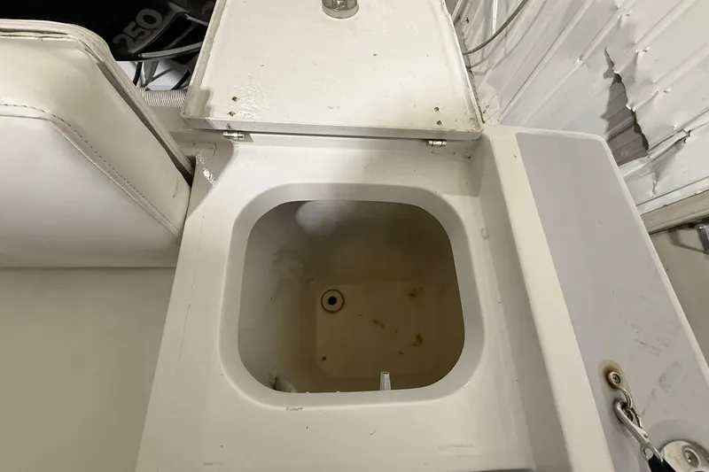 Slide: The Image of 1988 Stamas 255 Tarpon boat compartment with open lid, showing interior details. - 8