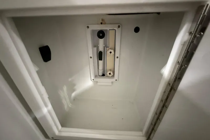 Slide: The Image of Compartment interior of 1988 Stamas 255 Tarpon boat, featuring a secure latch mechanism. - 9