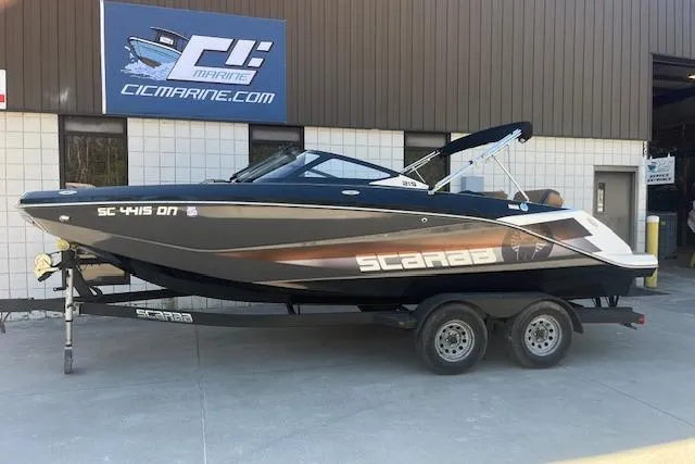 Slide: The Image of 2021 Scarab 215 ID boat on trailer outside CIC Marine building. - 26