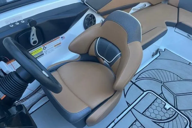 Slide: The Image of Captain's seat in a 2021 Scarab 215 ID boat, featuring tan and gray upholstery. - 36