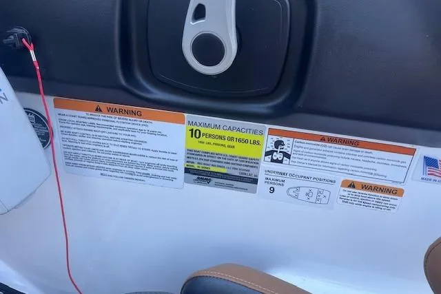 Slide: The Image of 2021 Scarab 215 ID boat capacity labels, warning signs, and safety instructions. - 49