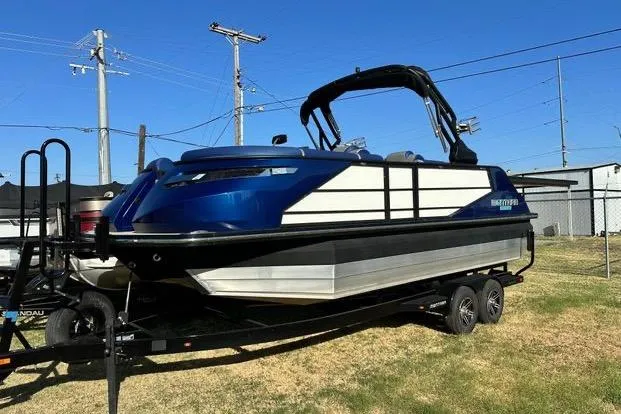 The Image of 2023 Montara 23 Surf Boss 2.0 CW boat on trailer, blue and white design. - 0