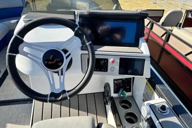 Slide: The Image of 2023 Montara 23 Surf Boss 2.0 CW boat dashboard with steering wheel and digital display. - 4