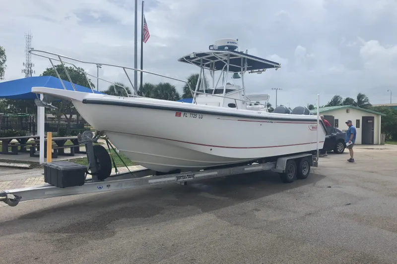 Slide: The Image of 2002 Boston Whaler 260 Outrage boat on trailer at a marina. - 11