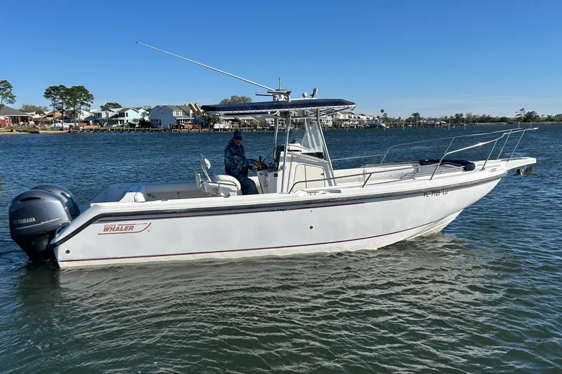 Slide: The Image of 2002 Boston Whaler 260 Outrage boat on water, featuring Yamaha engine, clear sky background. - 2