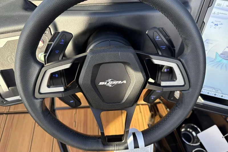 Slide: The Image of Steering wheel of 2026 Supra SE 550 with control buttons and display screen. - 14