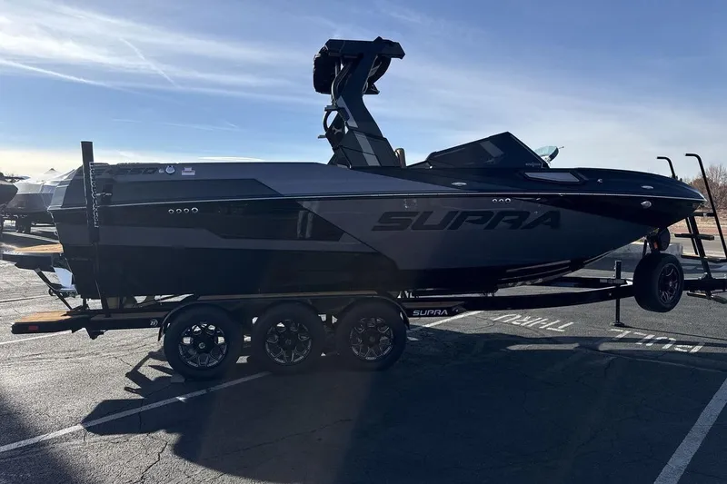 Slide: The Image of 2026 Supra SE 550 boat on trailer in parking lot, side view. - 6