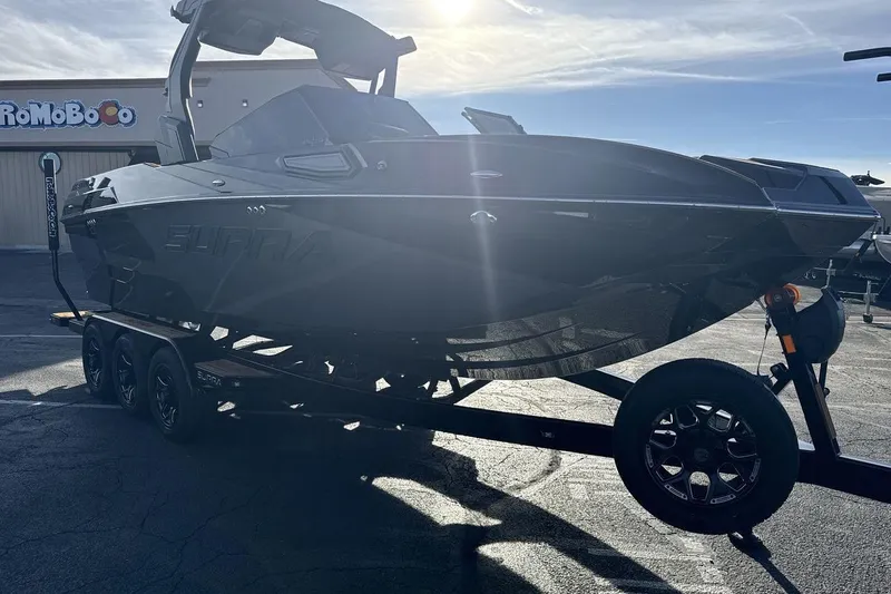 Slide: The Image of 2026 Supra SE 550 boat on trailer in sunny parking lot. - 7