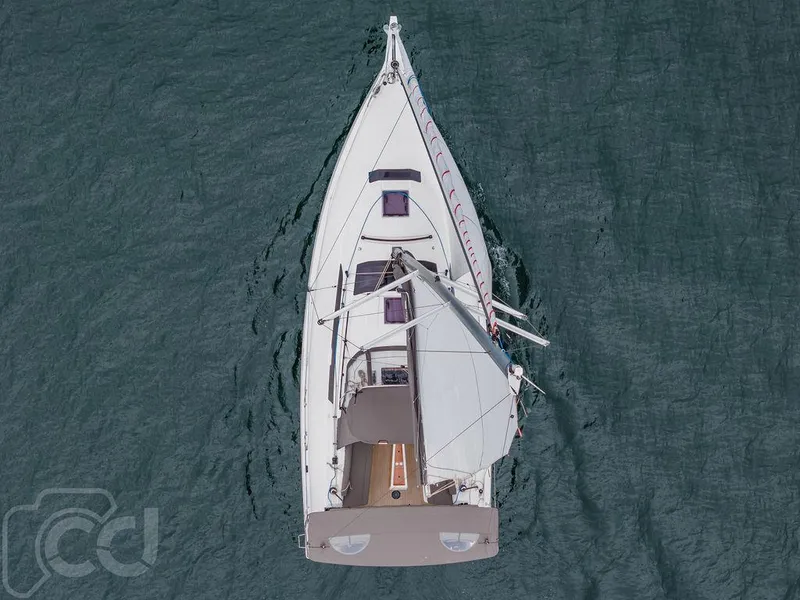 Slide: The Image of 2023 Dufour 37 sailboat in marina, featuring dual steering wheels and spacious cockpit. - 19