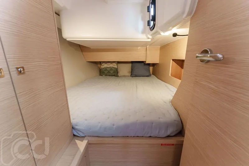 Slide: The Image of Interior of 2023 Dufour 37 yacht showing wooden storage shelves and cozy sleeping area. - 35