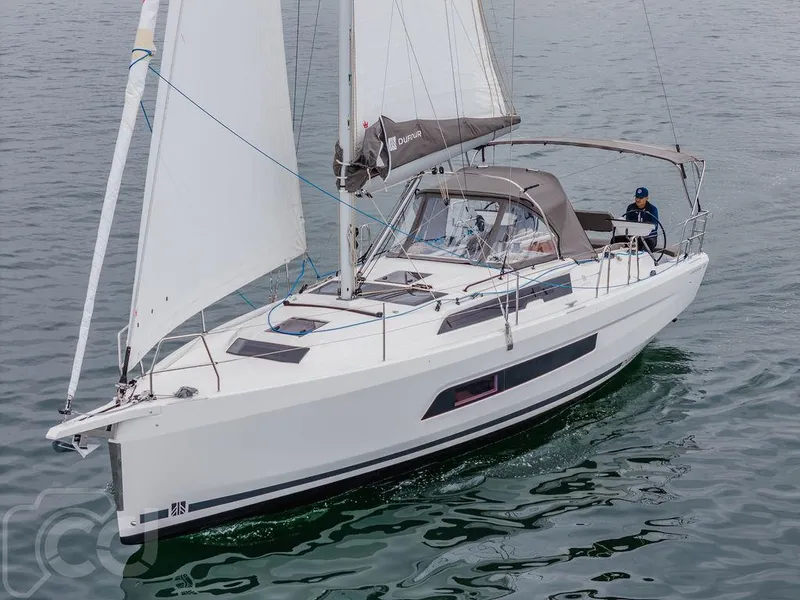 Slide: The Image of 2023 Dufour 37 sailboat on calm water, featuring sleek design and spacious deck. - 4