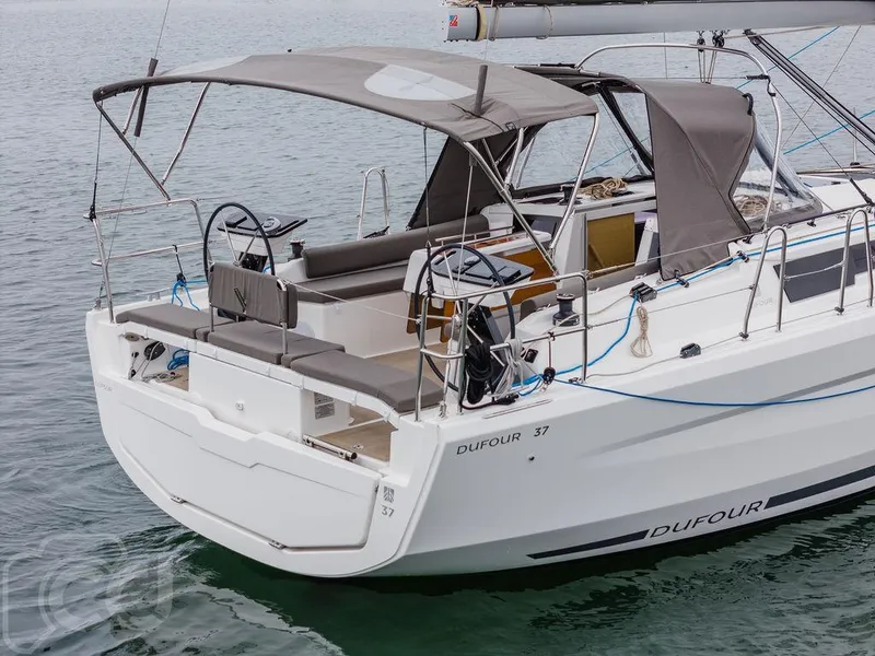 Slide: The Image of 2023 Dufour 37 sailboat on calm waters, overcast sky in the background. - 6