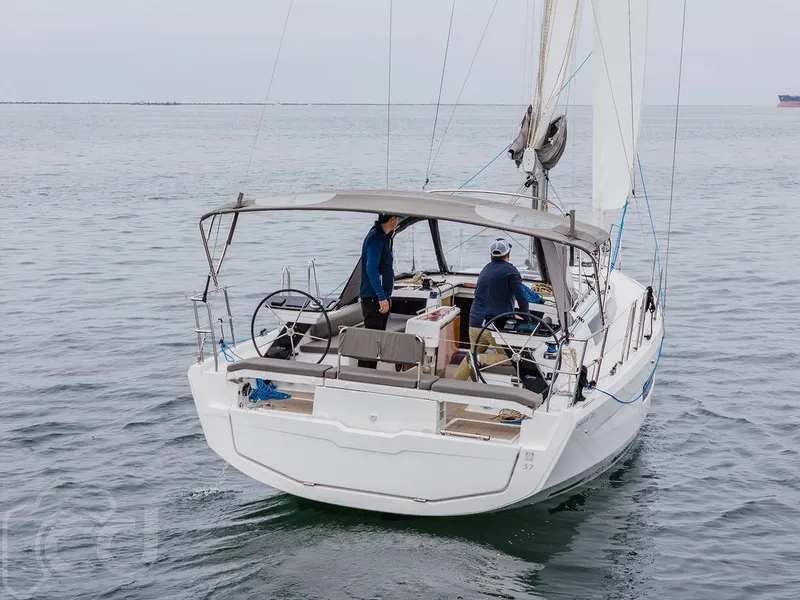 Slide: The Image of 2023 Dufour 37 sailboat with dual steering wheels and canopy on calm water. - 9