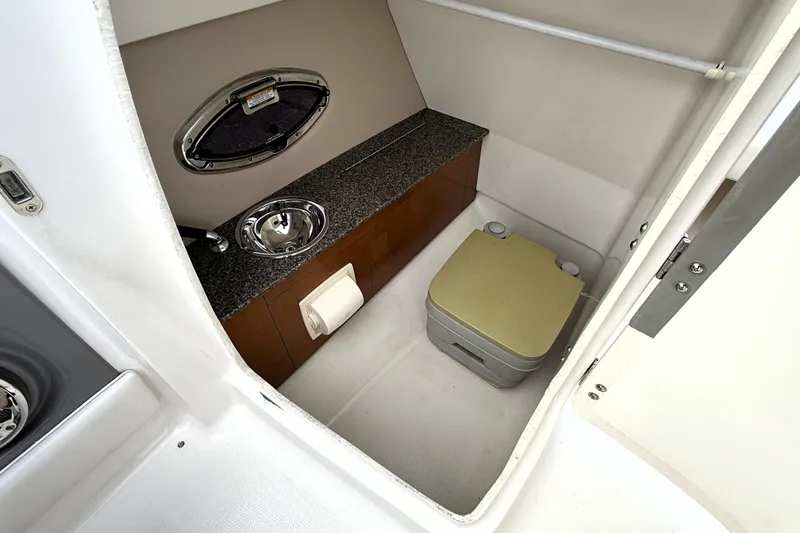 Slide: The Image of Interior of 2013 Chaparral 246 SSi boat featuring compact bathroom amenities. - 11