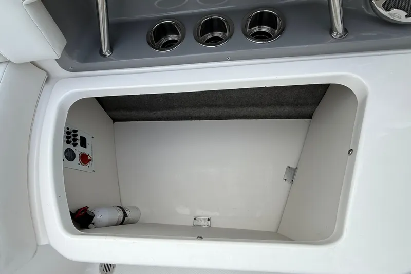 Slide: The Image of Storage compartment in a 2013 Chaparral 246 SSi boat with control panel and fire extinguisher. - 15