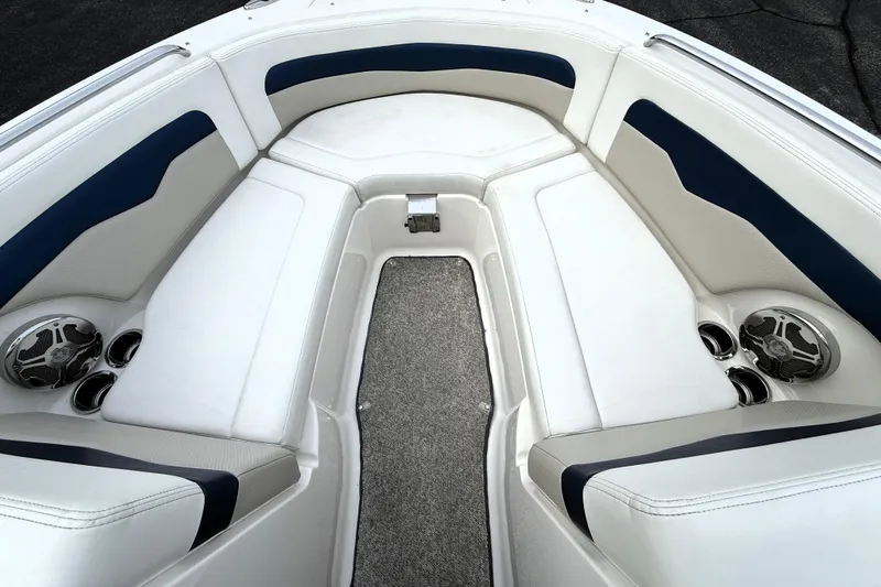 Slide: The Image of 2013 Chaparral 246 SSi boat interior with white and blue seating, speakers, and cup holders. - 28