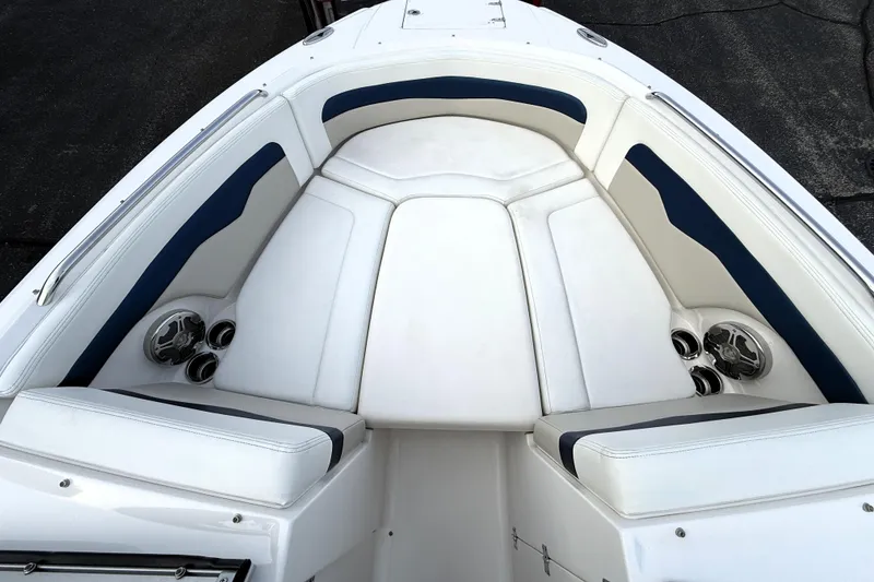 Slide: The Image of 2013 Chaparral 246 SSi boat interior with white and blue seating, cup holders, and speakers. - 9