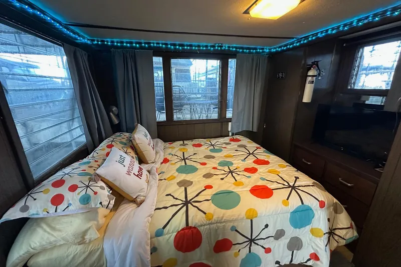 Slide: The Image of Cozy bedroom in a 1966 Lazy Days houseboat with colorful bedding and ambient lighting. - 10