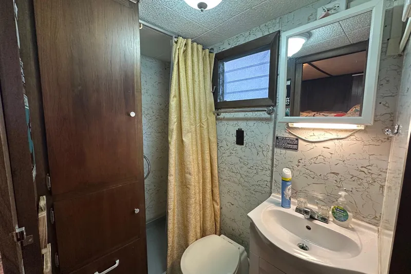 Slide: The Image of Compact 1966 Lazy Days RV bathroom with shower, sink, and storage cabinet. - 12