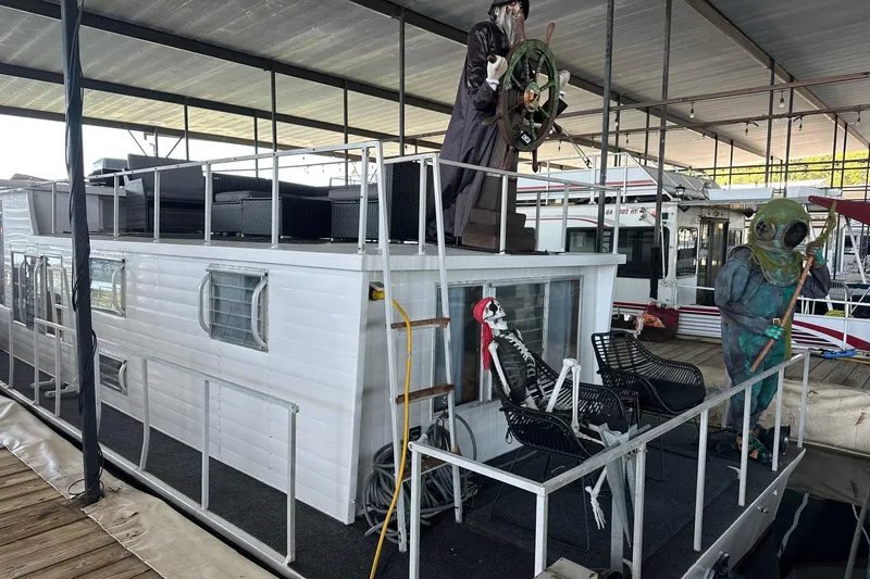 Slide: The Image of 1966 Lazy Days houseboat with pirate and diver decorations at a marina. - 13