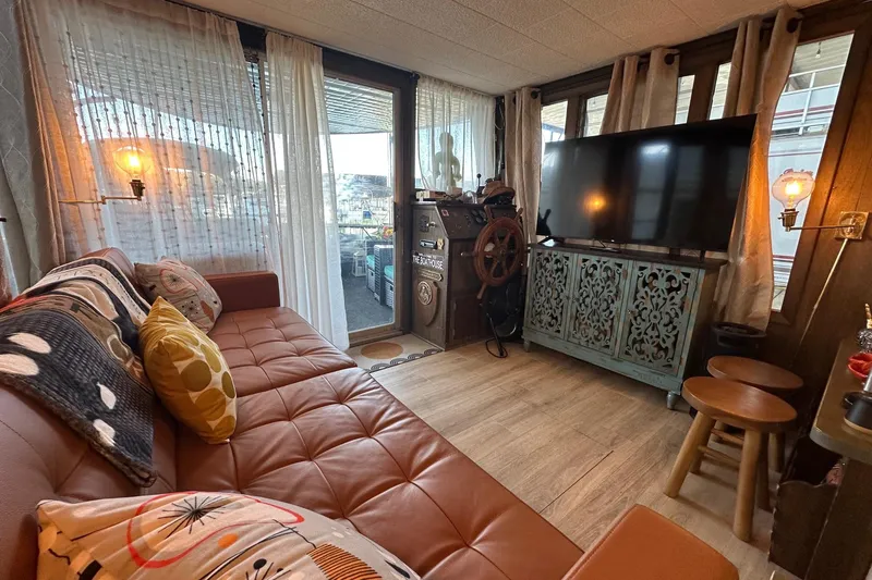 Slide: The Image of Cozy 1966 Lazy Days houseboat interior with vintage decor, large TV, and comfortable seating. - 3