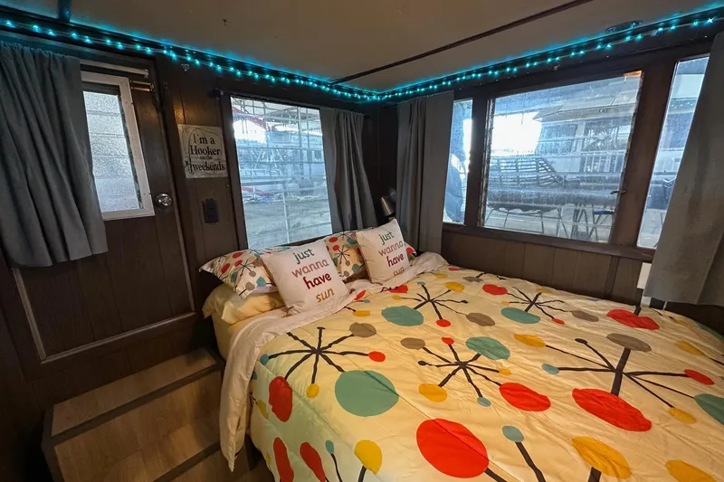 Slide: The Image of Cozy 1966 Lazy Days houseboat bedroom with colorful bedding and decorative pillows. - 9