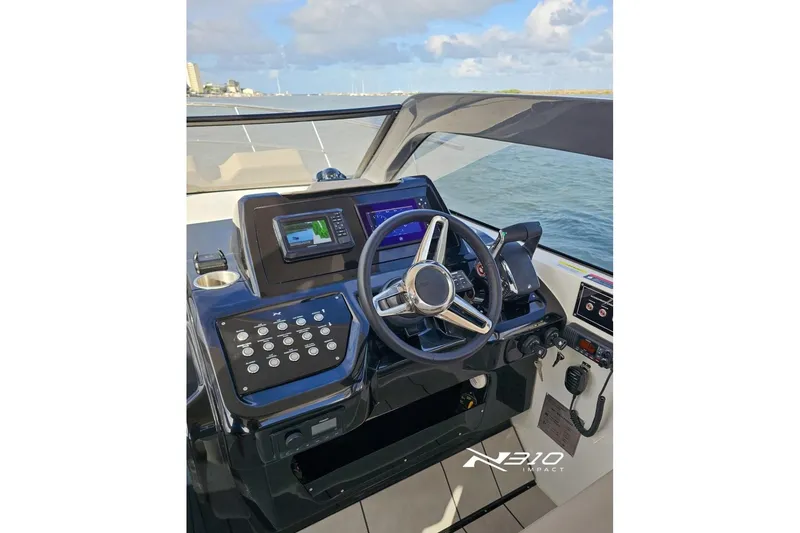 Slide: The Image of Helm of 2026 NX Boats NX310 with modern navigation controls and steering wheel. - 5