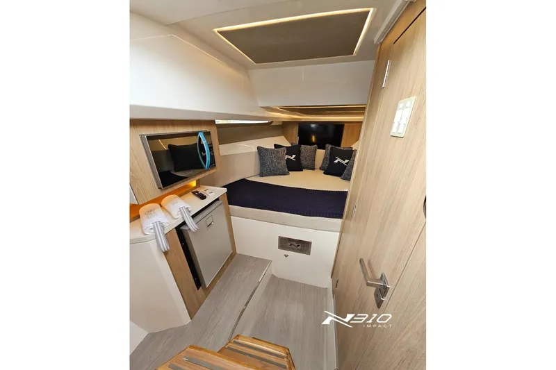 Slide: The Image of Interior of 2026 NX Boats NX310, featuring a cozy cabin with modern amenities. - 8