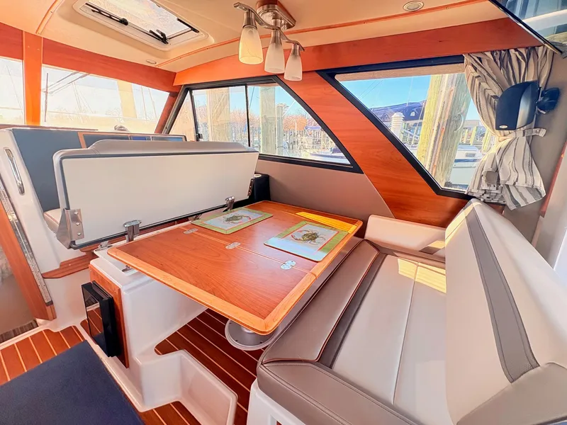 Slide: The Image of Interior of 2023 Cutwater 32 Coupe with wooden table and seating area. - 16