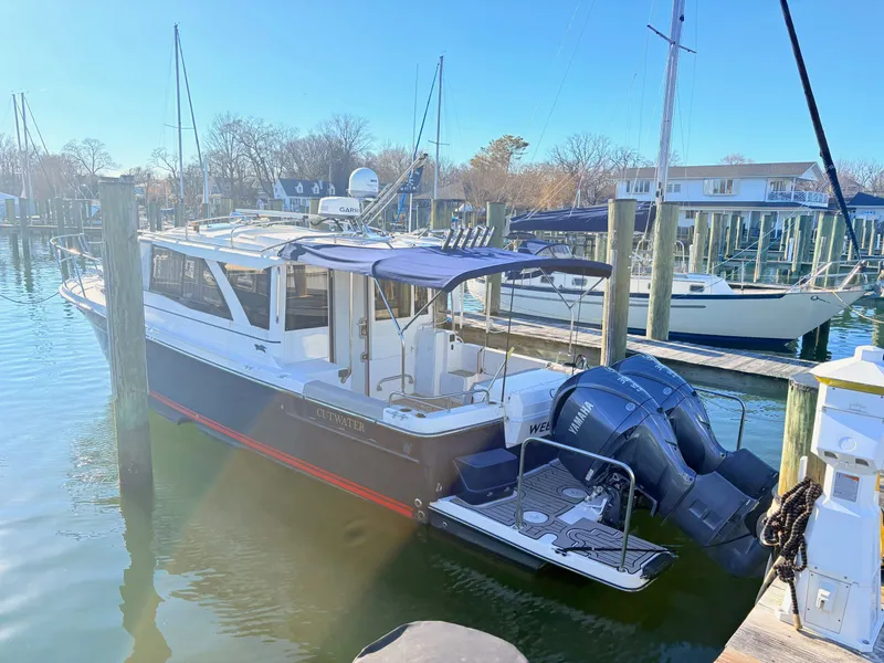 Slide: The Image of 2023 Cutwater 32 Coupe boat docked at marina. - 2