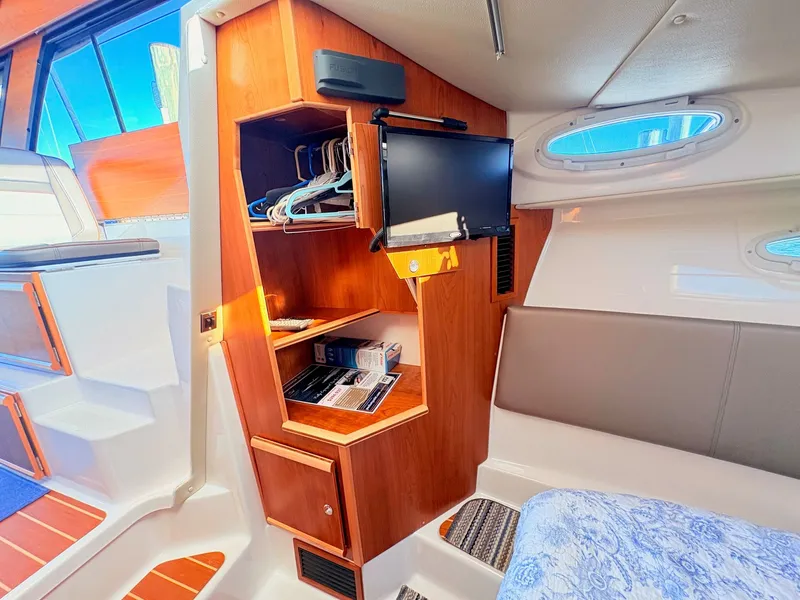Slide: The Image of Interior of 2023 Cutwater 32 Coupe with wooden cabinets and TV. - 26