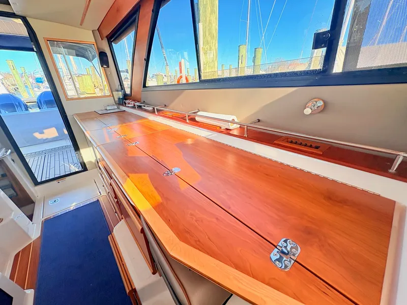 Slide: The Image of Interior of 2023 Cutwater 32 Coupe with wooden table and windows. - 29