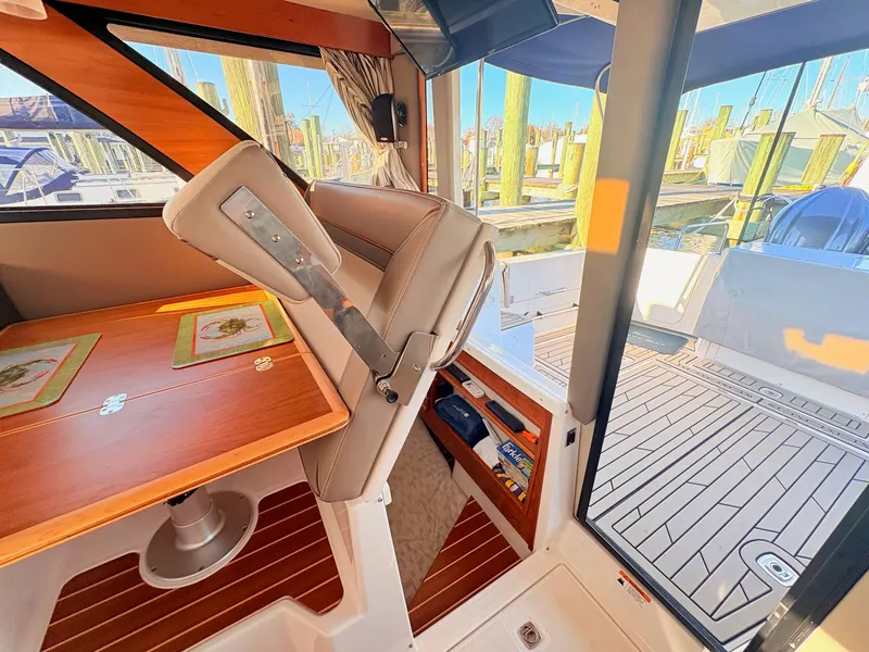 Slide: The Image of Interior of 2023 Cutwater 32 Coupe with wooden table and seating area. - 35