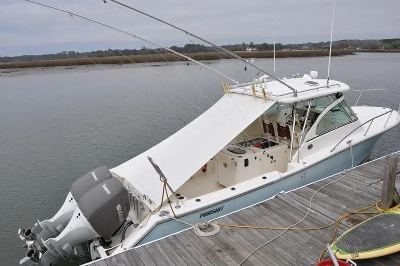The Image of 2006 Pursuit 345 Drummond Sportfish boat docked with fishing rods and twin engines. - 0
