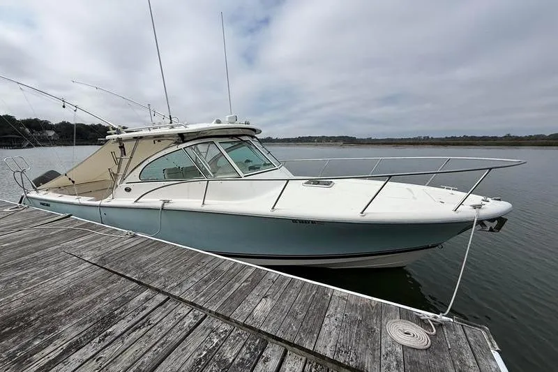 Slide: The Image of 2006 Pursuit 345 Drummond Sportfish boat docked on a wooden pier. - 1