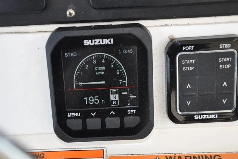 Slide: The Image of Suzuki engine control panel on 2006 Pursuit 345 Drummond Sportfish boat, showing 195 hours. - 10