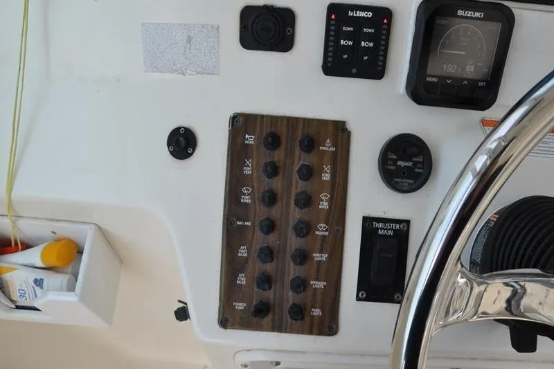 Slide: The Image of Control panel of a 2006 Pursuit 345 Drummond Sportfish boat with various switches and gauges. - 13