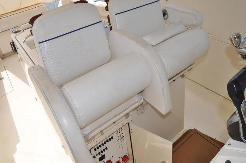 Slide: The Image of 2006 Pursuit 345 Drummond Sportfish boat interior with white seating and control panel. - 9