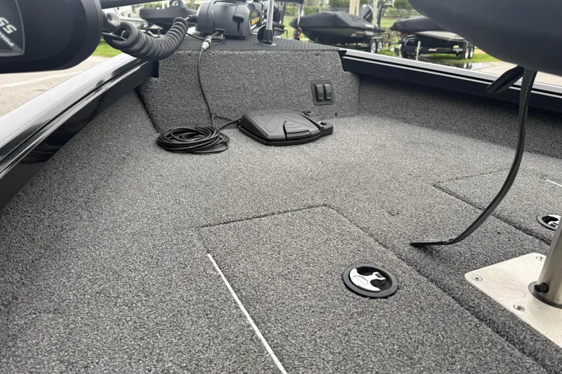 Slide: The Image of 2019 Ranger VS1660 boat interior with carpeted deck and fishing equipment. - 9