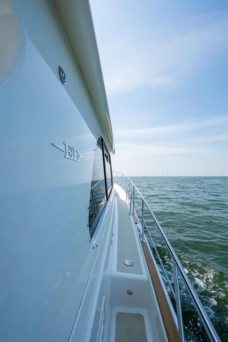 Slide: The Image of 2017 Grand Banks 44 Eastbay SX yacht cruising on open sea under clear blue sky. - 17
