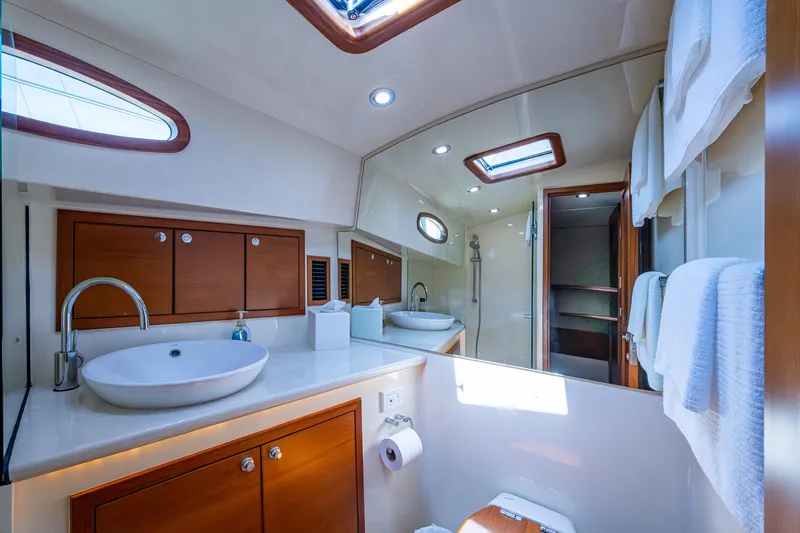 Slide: The Image of Luxurious bathroom in 2017 Grand Banks 44 Eastbay SX yacht, featuring modern fixtures and elegant wood cabinetry. - 34