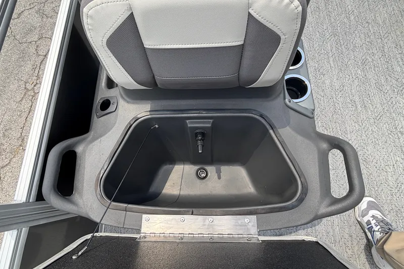 Slide: The Image of 2026 Sun Tracker Party Barge 20 DLX seat storage compartment with cup holders and handles. - 18