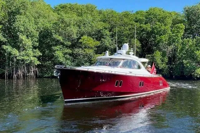 The Image of 2014 Zeelander Z44 yacht with red hull cruising on a serene river. - 0