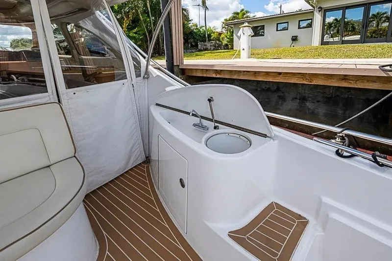 Slide: The Image of 2014 Zeelander Z44 yacht interior with seating and sink, docked by a waterfront home. - 2
