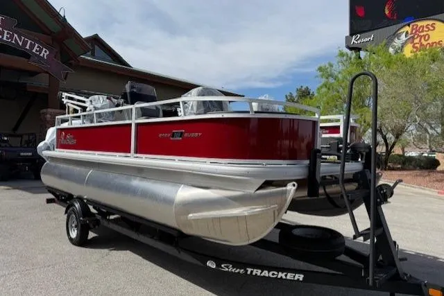 Slide: The Image of 2026 Sun Tracker Bass Buggy 18 DLX pontoon boat on trailer, parked outdoors. - 1