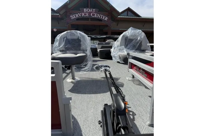 Slide: The Image of 2026 Sun Tracker Bass Buggy 18 DLX at boat service center, seats covered in plastic. - 5