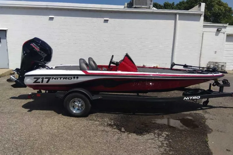 Slide: The Image of 2026 Nitro Z17 boat with trailer, parked outdoors, featuring sleek red and white design. - 4