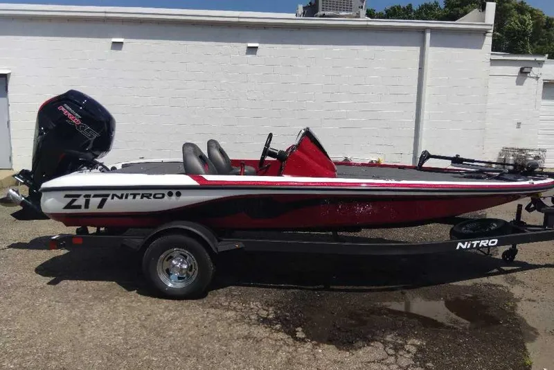 Slide: The Image of 2026 Nitro Z17 boat with trailer, parked outdoors, featuring sleek red and white design. - 5