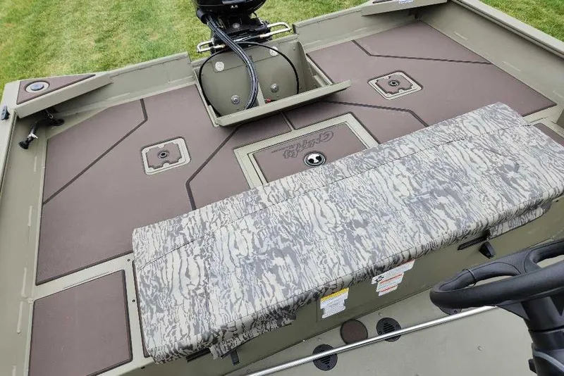 Slide: The Image of 2026 Tracker Grizzly 2072 CC boat interior with camo seating and storage compartments. - 54