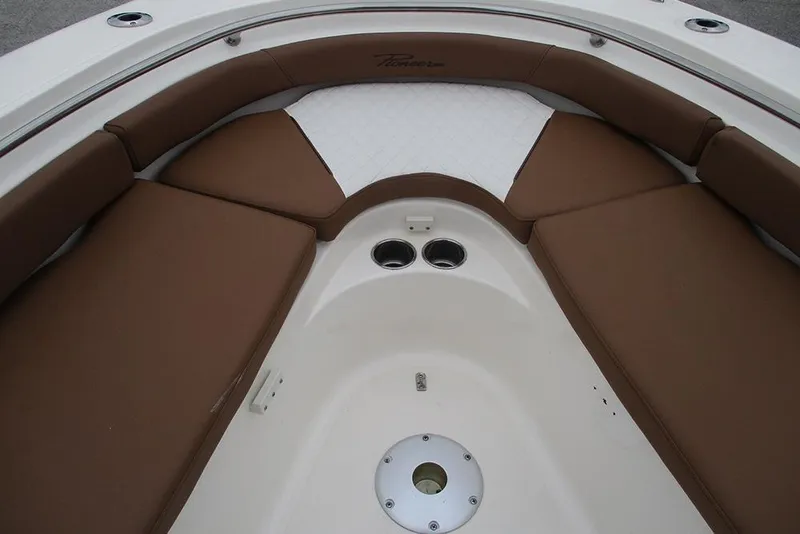 Slide: The Image of 2025 Pioneer 222 Islander boat interior with brown cushioned seating and cup holders. - 14